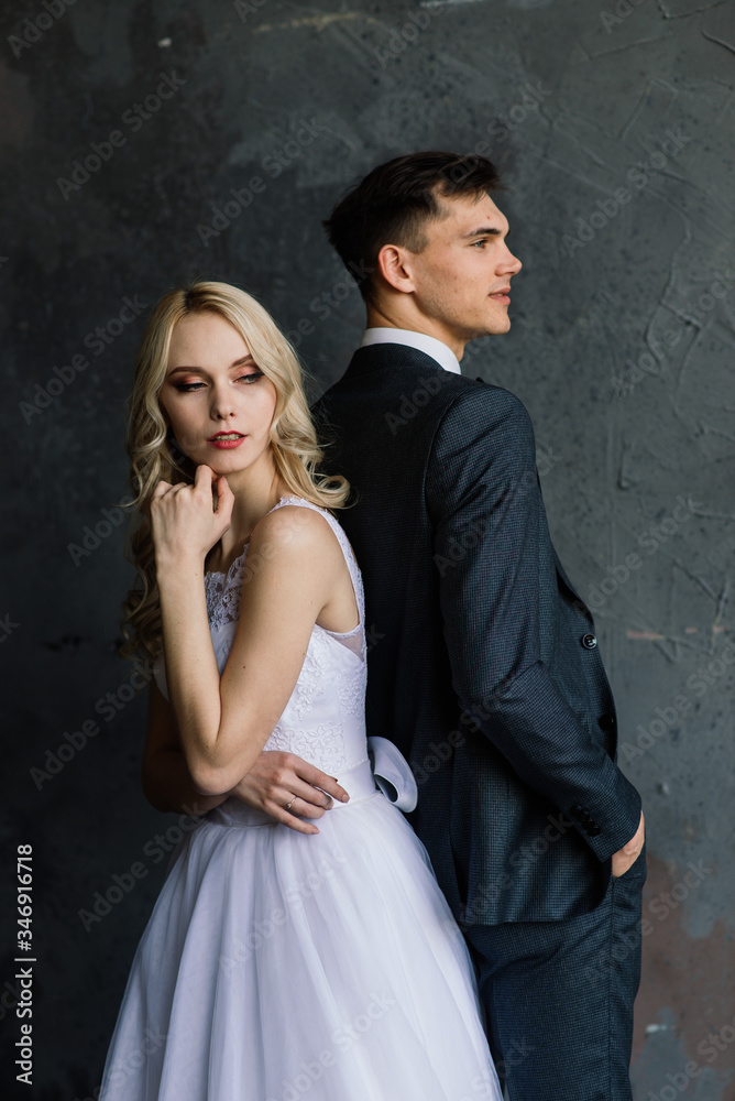 Cute wedding couple in the interior of a classic studio decorated. They kiss and hug each other. Cute wedding couple in the interior of a classic studio decorated. They kiss and hug each other.