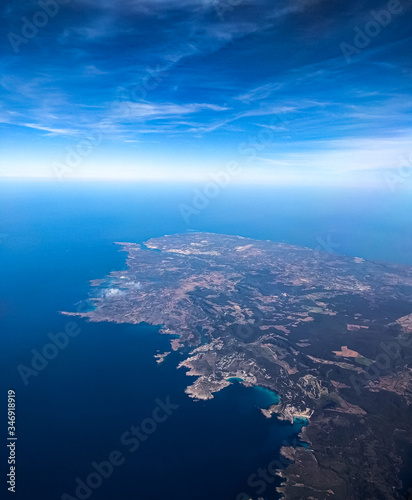 The Earth can be seen from the aircraft's porthole at high altitude. view from the porthole to the outlines of the island of Mallorca. View of the earth from a great height. Image with selective focus