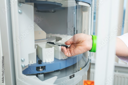 Hands of a laboratory technician close up conducting research with the help of an analyzer