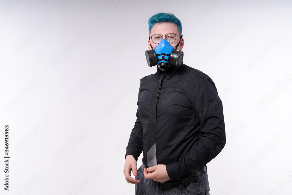 Man with blue hair, wearing casual clothes and blue protective face mask, looks in a camera, studio shot on white background Man with blue hair, wearing casual clothes and blue protective face mask, looks in a camera, studio shot on white background