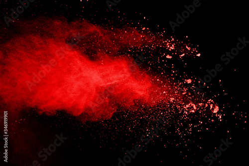 Explosion of red powder on black background.