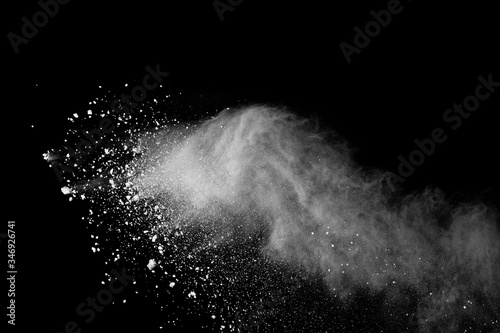 Freeze motion of white color powder exploding on black background.