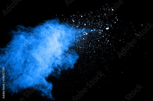 Blue dust explosion on black background. Freeze motion of color powder splash.