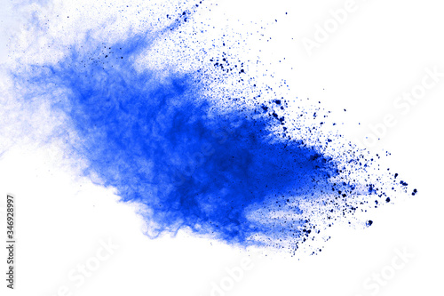 Abstract blue powder explosion on white background. Closeup of blue dust particles splash isolated on clear background.