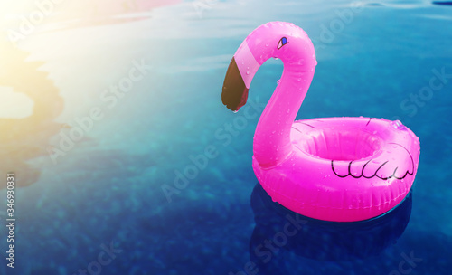 A little inflatable flamingo swims in a pool in the sunlight. Coasters for the pool. The concept of summer pastime. Beach summer composition © Алла Морозова