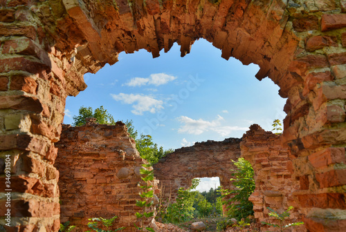 Εκτύπωση καμβά view of the blue sky through the ruined arch of a ruined castle overgrown with g