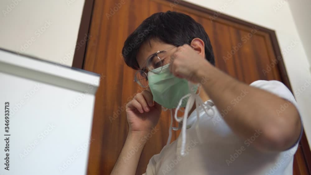 The man leaves the house and wears disposable medical mask puts the gloves in his hands with disinfectant. Safety during the coronavirus outbreak. Outbreak of the virus covid-19, covid
