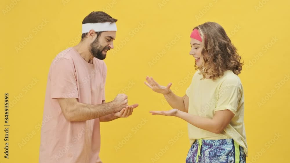 A smiling young athletic couple man and woman in sportswear are playing
Rock Paper Scissors isolated over a yellow background in studio A smiling young athletic couple man and woman in sportswear are playing
Rock Paper Scissors isolated over a yellow background in studio