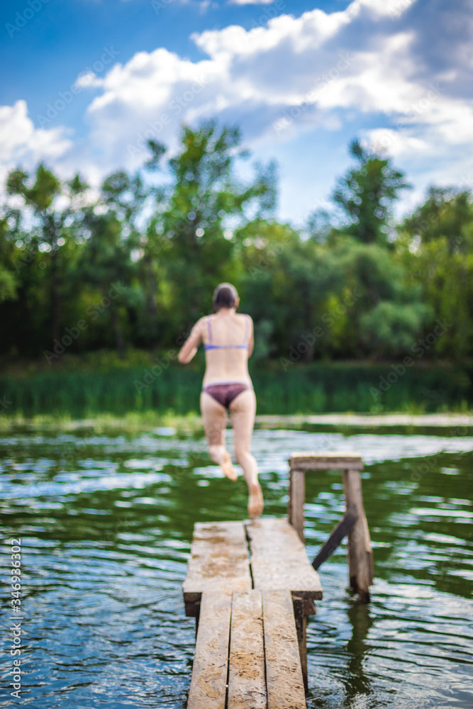 A beautiful woman jumping into the water from a pier. A beautiful woman jumping into the water from a pier.