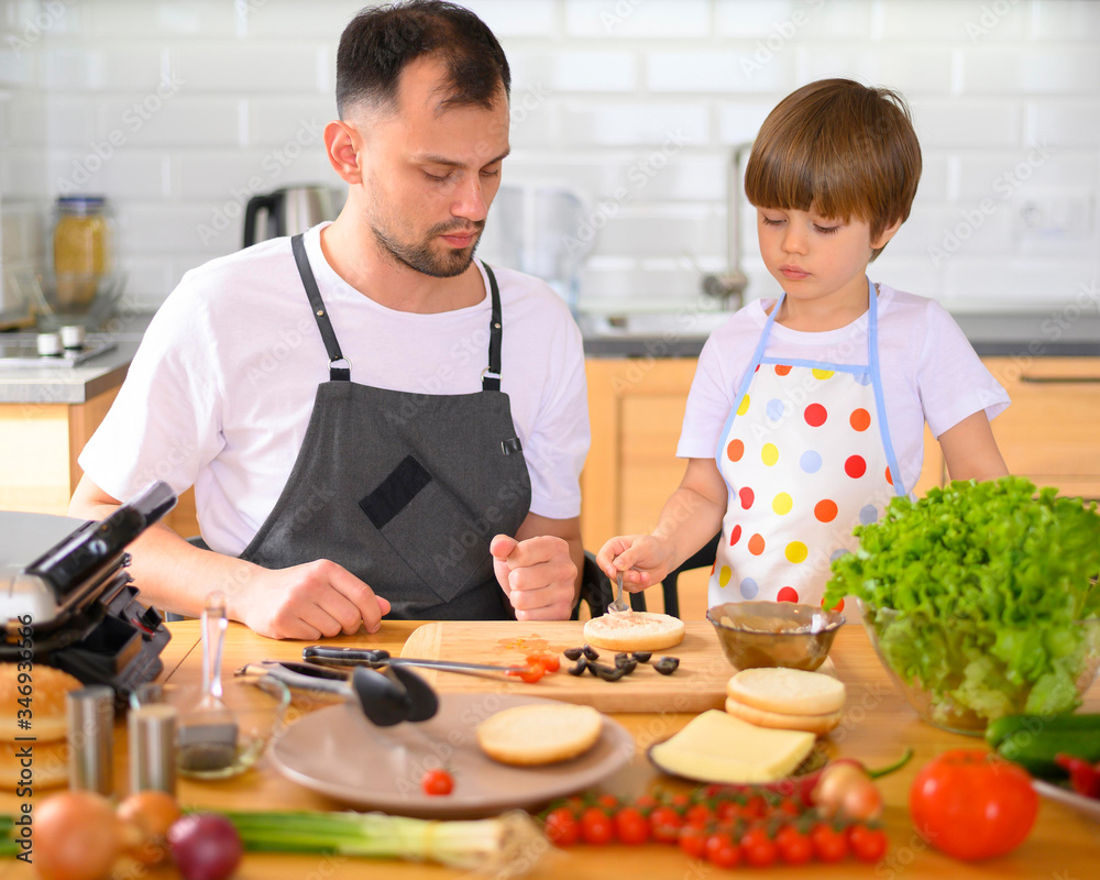 Father and son making a hamburger. Home cooking. Father and son making a hamburger. Home cooking.