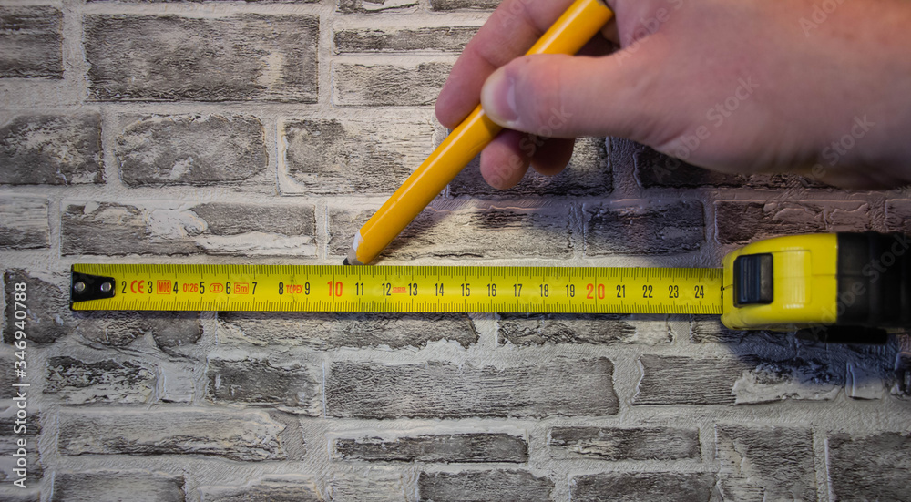 Measured with a tape measure and mark with a pencil on a brick wall.