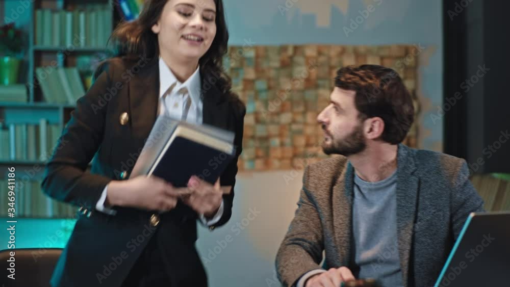 In the modern office handsome man manager and lady office worker have a discussing about some plan using a digital tablet to make some notes In the modern office handsome man manager and lady office worker have a discussing about some plan using a digital tablet to make some notes