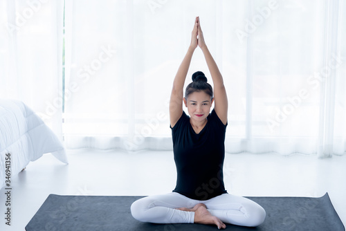 Fototapeta Naklejka Na Ścianę i Meble -  Pretty Asian middle-ages women are practicing yoga in the basic position in her bedroom, which is a warm-up and meditation exercise, concept to health care and recreation