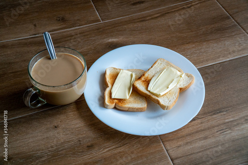 Obraz na płótnie Cup of coffe with milk and two slices of toasted sandwich buttered bread on a white plate. Healthy breakfast with coffee. Side view. Free space for text. w salonie