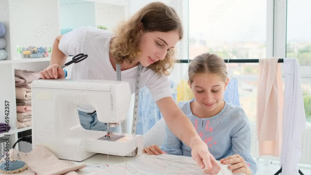 Girls looking at sketch in sewing atelier Girls looking at sketch in sewing atelier