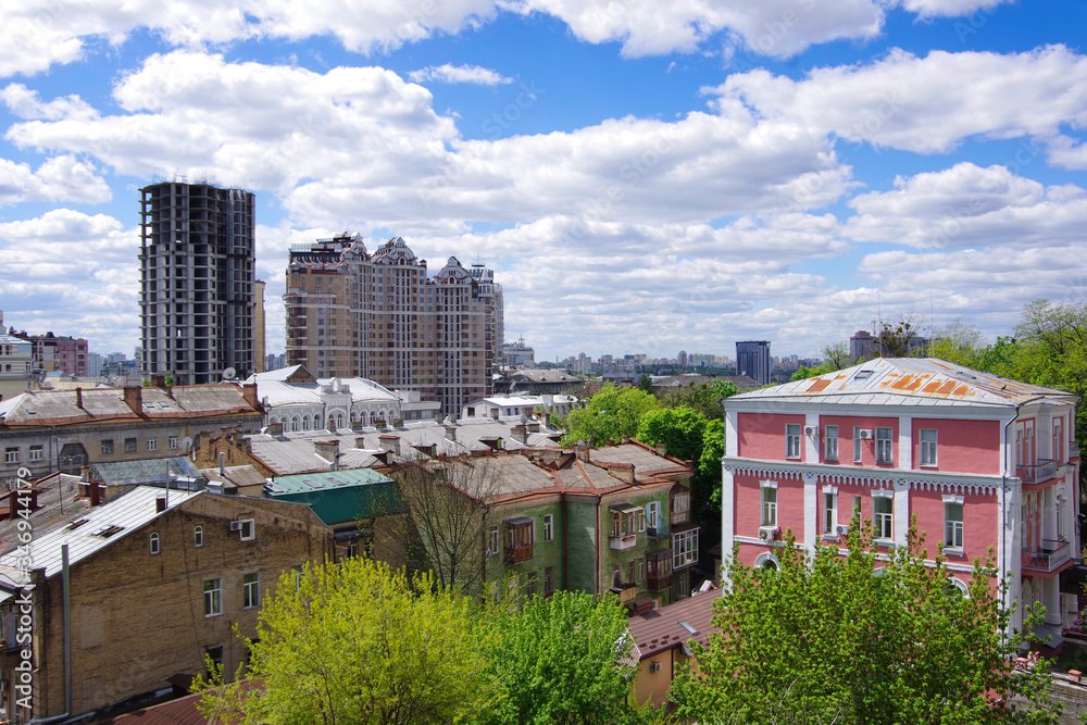 Kiev. Ukraine. 08/05/20. View of city buildings, new houses under construction in the distance under a bright blue sky.