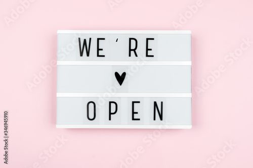 lightbox with the words WE are OPEN on a pink background