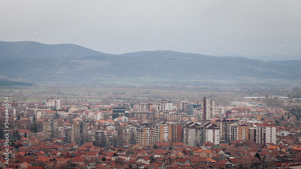 Hazy sky over desaturated Pirot cityscape, view from a vantage point 