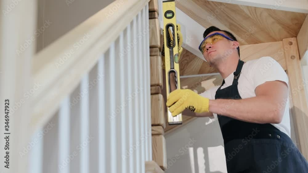 Vidéo Stock Carpenter installs stairs at new modern house. Construction