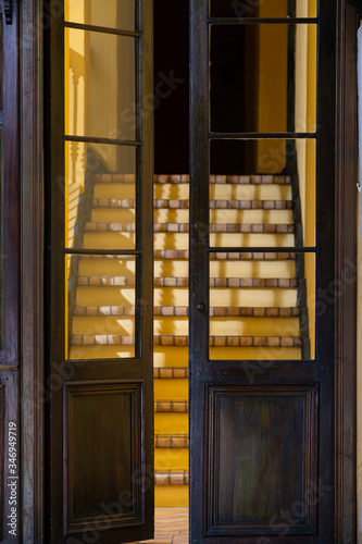 Puerta de madera con ventanas de construcción colonial.