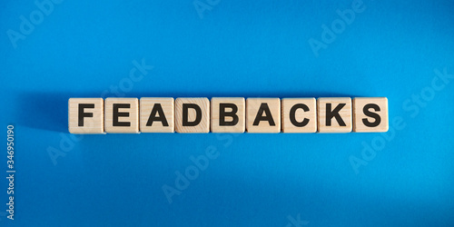 Feadbacks - conceptual text with wooden cubes on a dark blue background