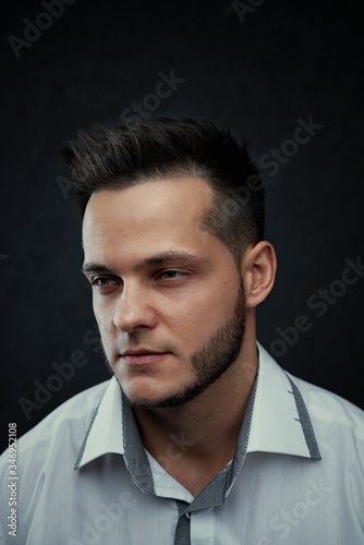 ortrait of handsome young man against studio background. Perfect hairstyle, modern stylish haircut. Attractive guy with fashion hairstyle. Confident man with short beard. Barbershop concept.