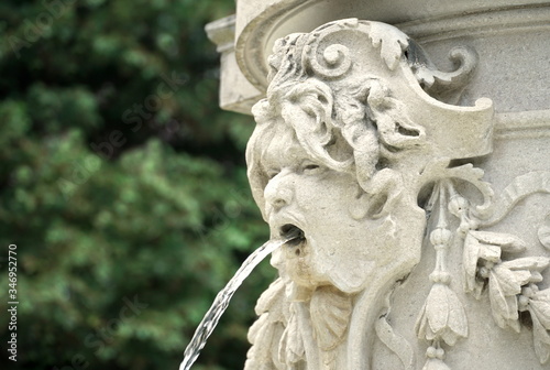 Fountain with water. Detail of the street fountain, the head of a mythological being with water in mouth