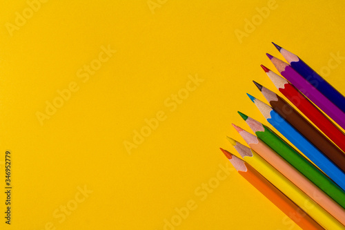 Color pencils isolated on yellow background close up photo