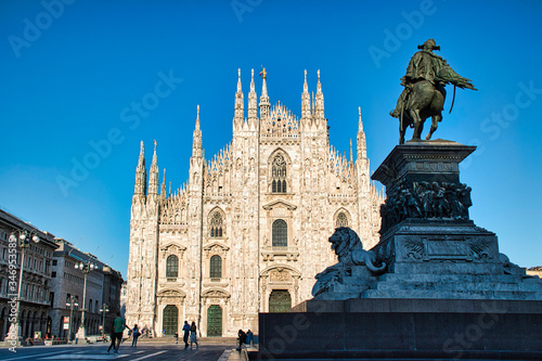 The golden sunshine is reflecting on the front of the magnificent Duomo di Milano or Milan Cathedral after Italy eases coronavirus restrictions
