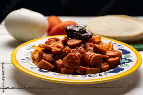Mexican sausage with chipotle sauce on white background