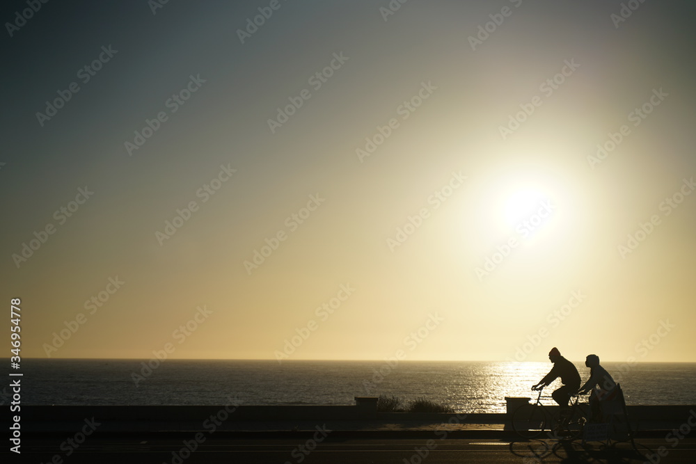 silhouette of people on bicycle