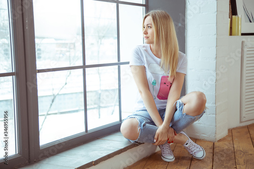 Loneliness self-isolation, a girl sitting at a large window, a sad look Free Download Loneliness self-isolation, a girl sitting at a large window, a sad look - GFXLoad