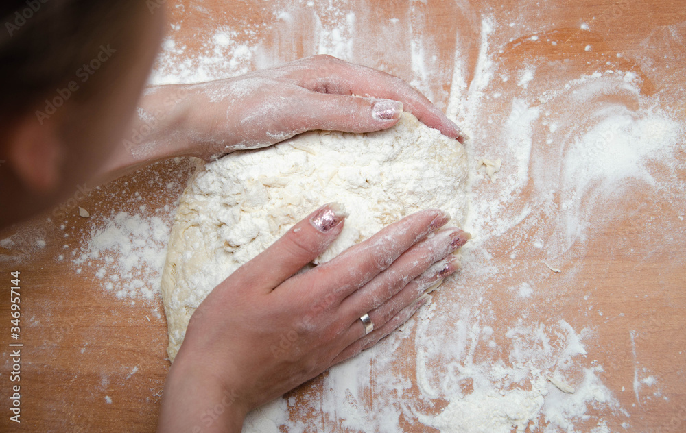 Female hands knead, knead the pizza dough. Dough, flour, cook, pizza. Girl rolls rolling pin dough Female hands knead, knead the pizza dough. Dough, flour, cook, pizza. Girl rolls rolling pin dough