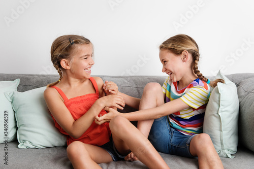 Young girls tickling each other on sofa