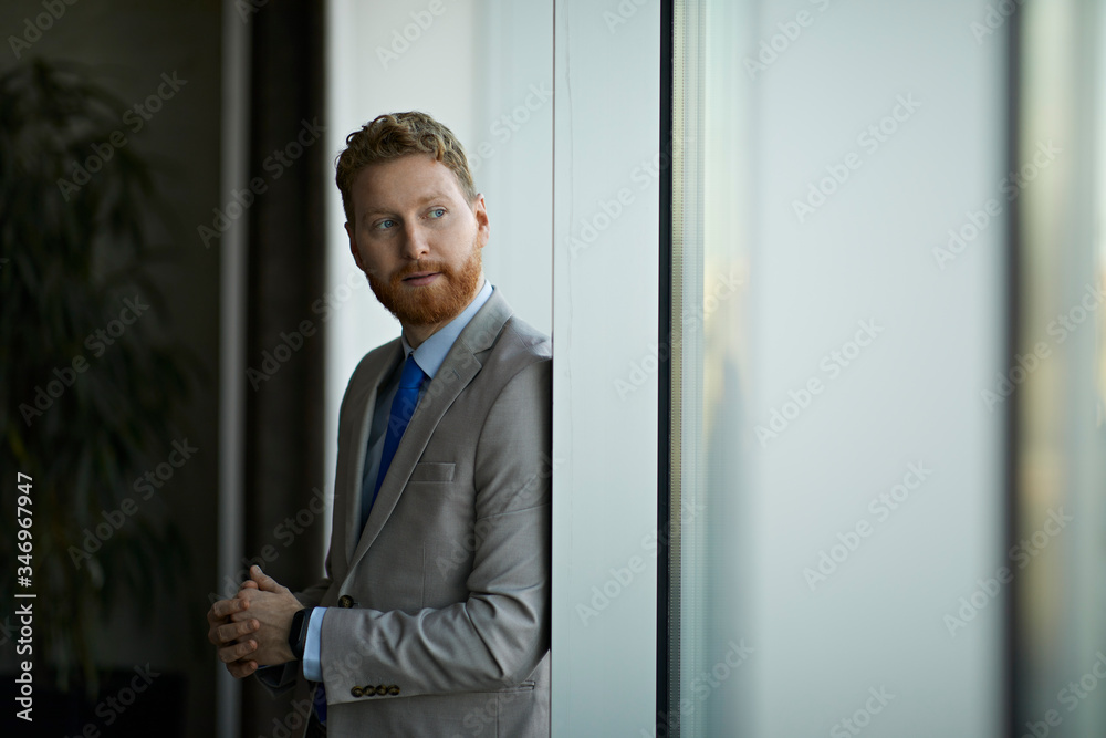 Portrait of a businessman looking out of window Portrait of a businessman looking out of window