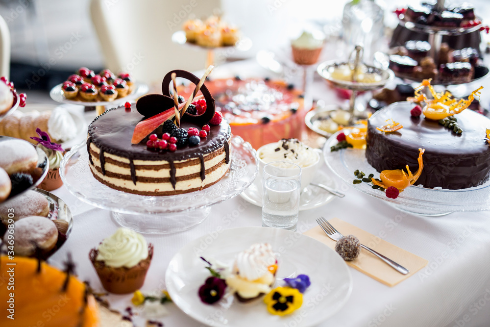 Dining table filled with all kinds of snacks and desserts Dining table filled with all kinds of snacks and desserts