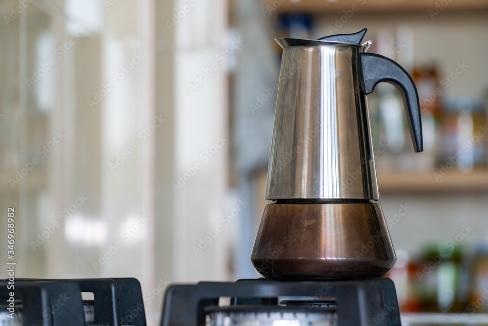 Italian espresso coffee maker or Moka pot on the gas stove. Metal coffee maker in a kitchen
