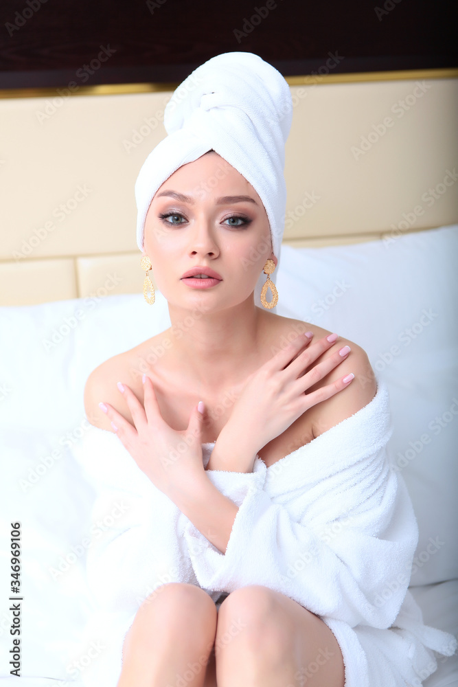 A beautiful girl with a towel on her head looks into the camera lens. Concept of Spa treatments or recreation. A beautiful girl with a towel on her head looks into the camera lens. Concept of Spa treatments or recreation.
