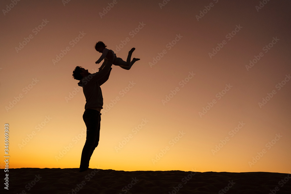 Father playing with daughter on sand dune at sunset, Gran Canaria, Spain Father playing with daughter on sand dune at sunset, Gran Canaria, Spain
