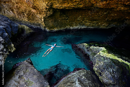 Woman floating on clear watr in a grotto photo