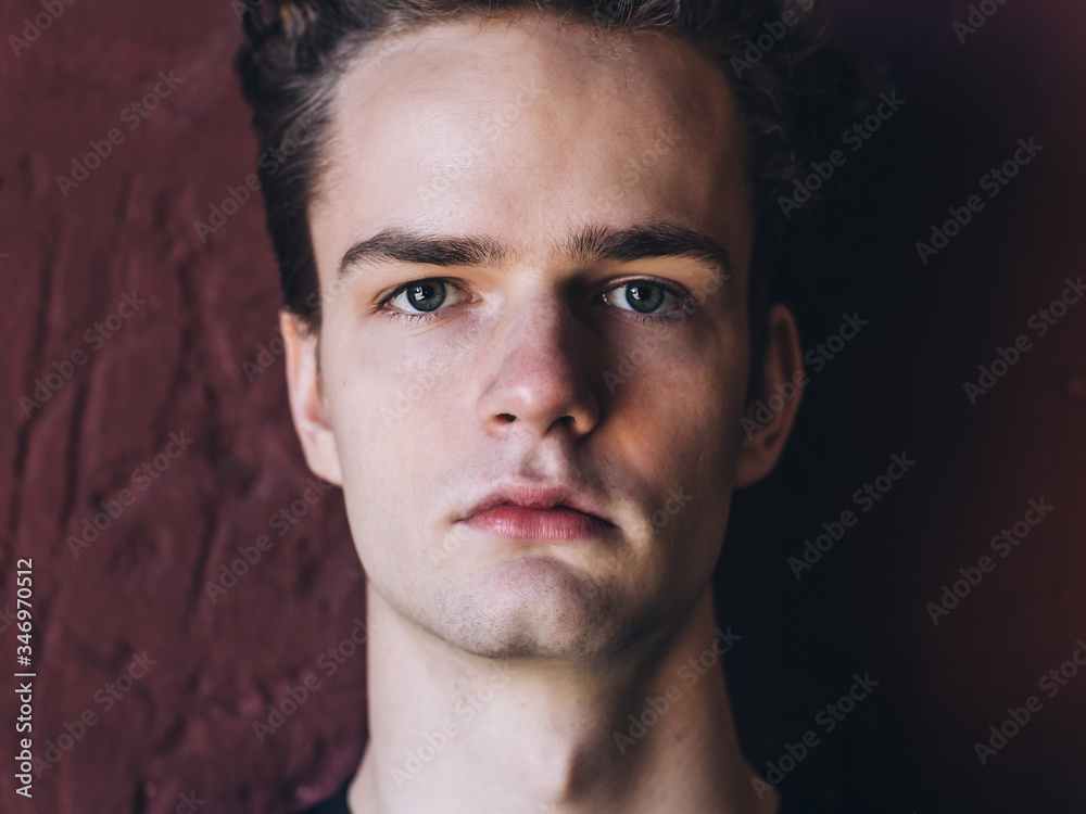 Obraz premium closeup portrait of a serious young man, teenager on wall background