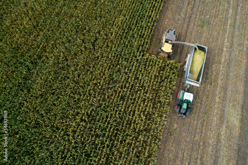Germany, Bavaria, Drone view of combine and tractor harvesting corn