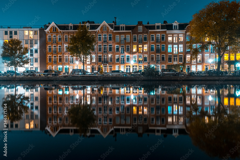 Beautiful smooth reflection of a residential area over the river in Amsterdam.