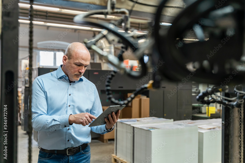 Businessman using tablet in a factory Businessman using tablet in a factory