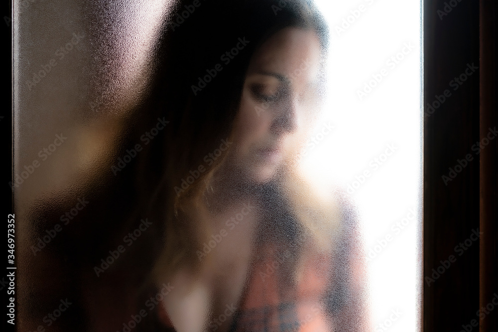 Portrait of mature woman with eyes closed behind glass pane Portrait of mature woman with eyes closed behind glass pane