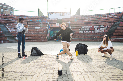 Young dancers rehearsing in a skare park, friends making a video photo