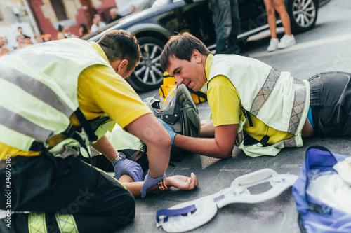 Paramedics helping crash victim after scooter accident photo