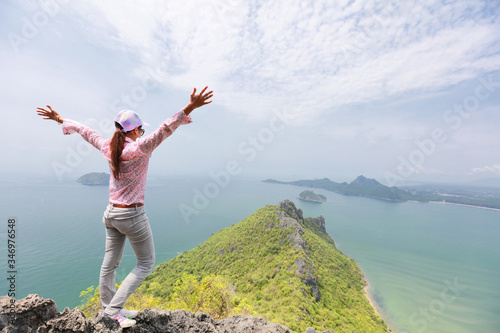 woman rising hands on mountain feel happy and freedom to achieve of hikking trip 