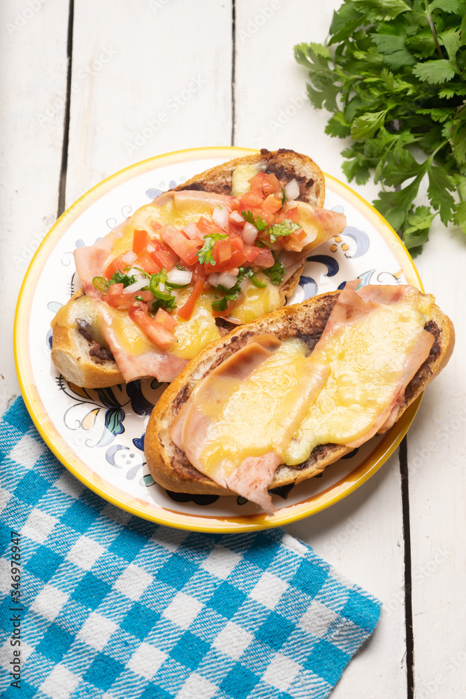 Mexican molletes with ham and cheese on white background Mexican molletes with ham and cheese on white background