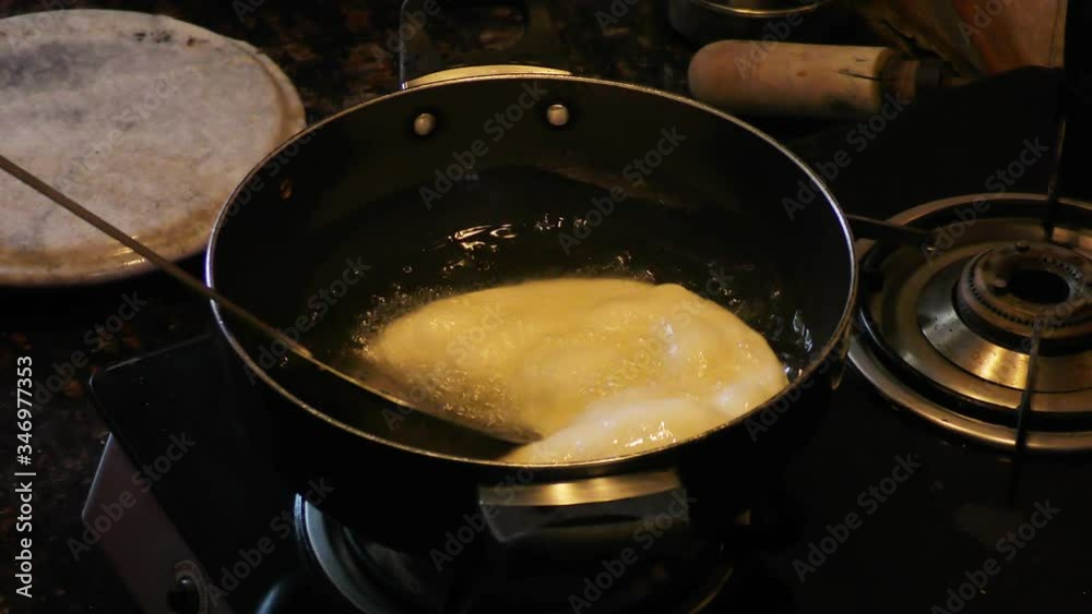 Frying bhature in hot oil in pan on the heater Frying bhature in hot oil in pan on the heater